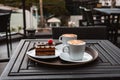 Slice of chocolate cake, Cutlery steak basket and donot with coffee on the table