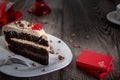 Slice of a chocolate cake and a red gift box