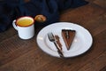 Slice of chocolate cheesecake on a white plate served with a fork and cup of orange juice Royalty Free Stock Photo