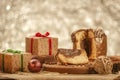 Slice of chocolate panettone on wooden cutting board with christmas ornaments