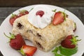 Slice of cream puff cake with strawberry on wooden table Royalty Free Stock Photo