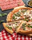 Slice of cut meat pizza with arugula and tomato. Close up shot. Fast food cooking. Classic italian cuisine. Soft Focus