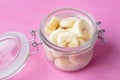 Slice cutted banana in glass pot on pink background