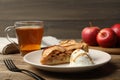 Slice of delicious apple pie served with ice cream and tea on wooden table Royalty Free Stock Photo