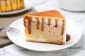 Slice of delicious cake with caramel sauce on marble table Royalty Free Stock Photo