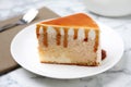 Slice of delicious cake with caramel sauce on marble table Royalty Free Stock Photo