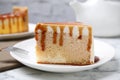 Slice of delicious cake with caramel sauce on marble table Royalty Free Stock Photo