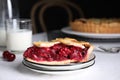 Slice of delicious fresh cherry pie on table against dark background Royalty Free Stock Photo