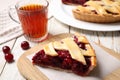 Slice of delicious fresh cherry pie on white wooden table, closeup Royalty Free Stock Photo