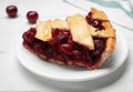 Slice of delicious fresh cherry pie on white wooden table, closeup Royalty Free Stock Photo