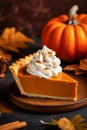 Slice of delicious home baked traditional Thanksgiving pumpkin pie with whipped cream on a plate. Holiday pastry