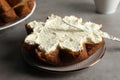 Slice of delicious Pandoro cake with cream on grey table