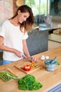 Slice and dice. an attractive young woman chopping vegetables in a kitchen. Royalty Free Stock Photo