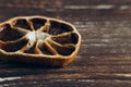 Slice of dried orange on a textural wooden table