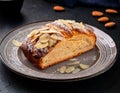 A slice of Estonian kringel bread topped with sugar crystals and almonds, served on a ceramic plate Royalty Free Stock Photo