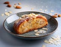 A slice of Estonian kringel bread topped with sugar crystals and almonds, served on a ceramic plate Royalty Free Stock Photo