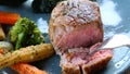 Close up of man hand cut slice of fresh grilled steak in luxury restaurant