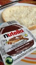 Slice of freshly-baked bread accompanied by a packet of creamy, delicious Nutella Royalty Free Stock Photo