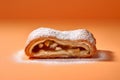 Slice of German apple strudel pastry on orange background