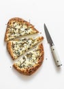 Slice of gorgonzola, pear, honey, sesame pizza on a light background, top view