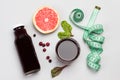 Slice of grapefruit, cranberries, juice in glass and in bottle, measuring tape