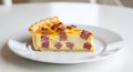 A slice of ham and cheese quiche on a white plate on a white surface top Royalty Free Stock Photo