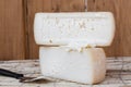 Slice of hard cheese, goat`s milk cutting with cheese knife . Typical soft texture and whitish color. Farm homemade