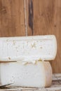 Slice of hard cheese, goat`s milk cutting with cheese knife . Typical soft texture and whitish color. Farm homemade