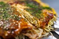 A slice of Hiroshima style Okonomiyaki with sweet soy sauce. Close up image of Japanese layered pancake