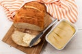 Slice home baked bread with margarine on a cutting board