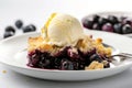 Slice of home baked delicious blueberry crumble with a scoop of vanilla ice cream on a plate with juicy jammy berry filling on Royalty Free Stock Photo