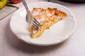 Slice of homemade apple pie and fork on light marble background Royalty Free Stock Photo