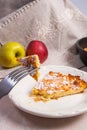 Slice of homemade apple pie and fork on light marble background Royalty Free Stock Photo