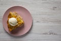 Slice of homemade apple pie with ice cream on a pink plate over white wooden background, top view Royalty Free Stock Photo