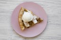 Slice of homemade apple pie with ice cream on pink plate over white wooden background, top view. Flat lay, overhead, from above Royalty Free Stock Photo