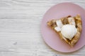 Slice of homemade apple pie with ice cream on pink plate. White wooden background. Copy space. Flat lay, overhead, from above Royalty Free Stock Photo