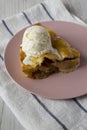 Slice of homemade apple pie with vanilla ice cream on a pink plate, side view. Close-up Royalty Free Stock Photo