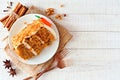 Slice of homemade carrot cake with cream cheese frosting, above view over white wood background Royalty Free Stock Photo