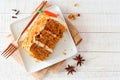 Slice of homemade carrot cake with cream cheese frosting, top view table scene over white wood Royalty Free Stock Photo