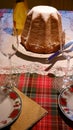 Slice of homemade pandoro with Christmas dish and tartan