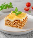 Slice of Lasagna bolognese with meat sauce and bechamel with melted cheese on top and fresh basil. Italian cusine. Copy space Royalty Free Stock Photo