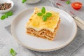 Slice of Lasagna bolognese with meat sauce and bechamel with melted cheese on top and fresh basil. Italian cusine. Copy space Royalty Free Stock Photo