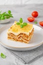 Slice of Lasagna bolognese with meat sauce and bechamel with melted cheese on top and fresh basil. Italian cusine. Copy space Royalty Free Stock Photo