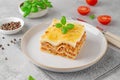 Slice of Lasagna bolognese with meat sauce and bechamel with melted cheese on top and fresh basil. Italian cusine. Copy space Royalty Free Stock Photo