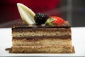 Slice of layered chocolate cake topped with a strawberry and bl
