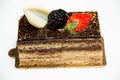 Slice of layered chocolate cake topped with a strawberry and bl