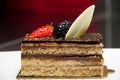 Slice of layered chocolate cake topped with a strawberry and bl