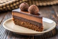 Chocolate Mousse Cake Slice with Two Truffles on a Beige Plate with Wooden Background chocolate cake Royalty Free Stock Photo
