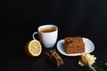 Slice of layered honey cake Medovik decorated with anise star on white plate, sticks of cinnamon, a cup of tea with lemon, place f Royalty Free Stock Photo