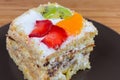 Slice of layered sponge cake with fruits decoration closeup Royalty Free Stock Photo